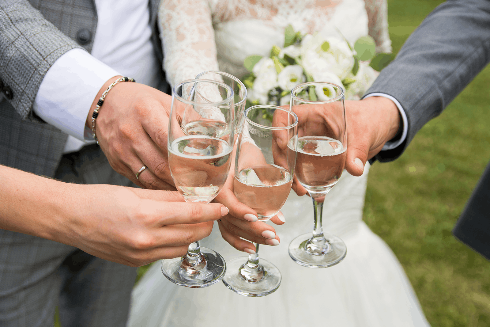 A couple and their guests raising glasses of champagne in a toast
